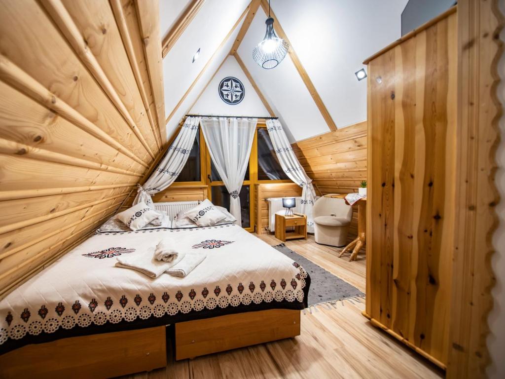 a bedroom with a bed in a wooden house at Pokoje Małgorzatka in Zakopane
