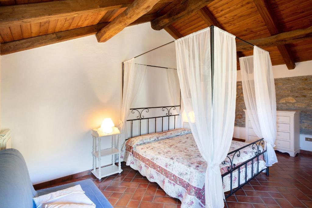 1 dormitorio con 1 cama con dosel en La Casa della nonna, en Vessalico