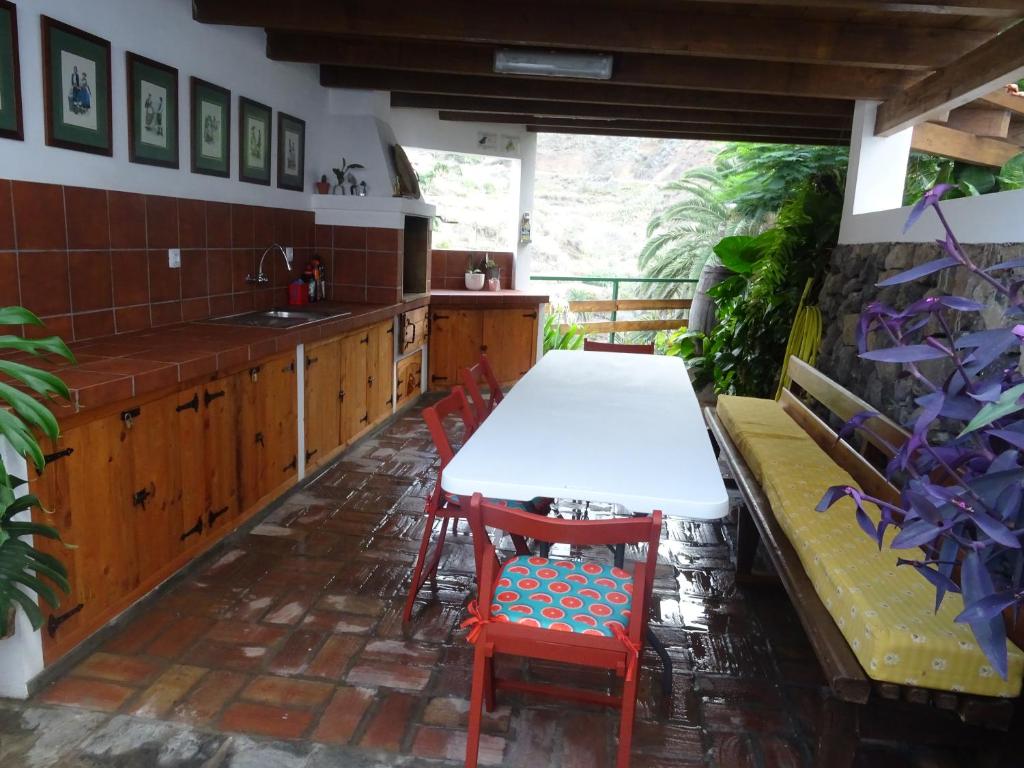 Casa La Poyata - Taganana في سانتا كروث دي تينيريفه: مطبخ مع طاولة وكراسي ومغسلة
