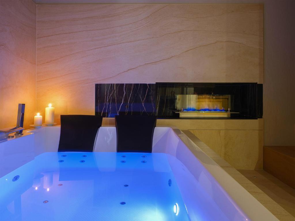 a bath tub with two chairs in a room at SaxAurea in Matera