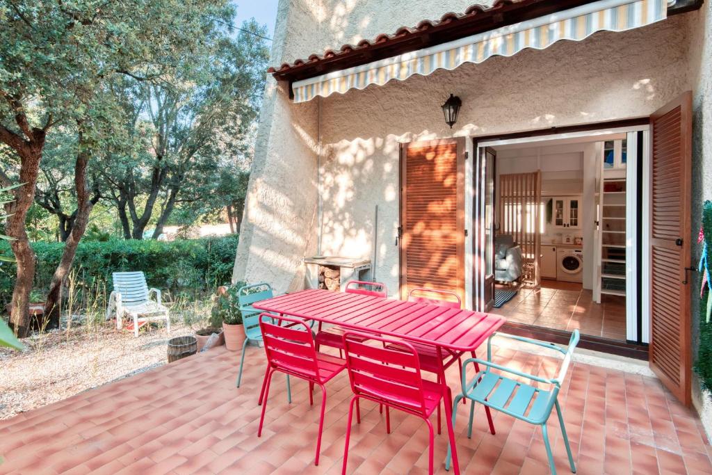 uma mesa vermelha e cadeiras num pátio em Traditional house in a calm residence in Sanary-sur-Mer - Welkeys em Sanary-sur-Mer