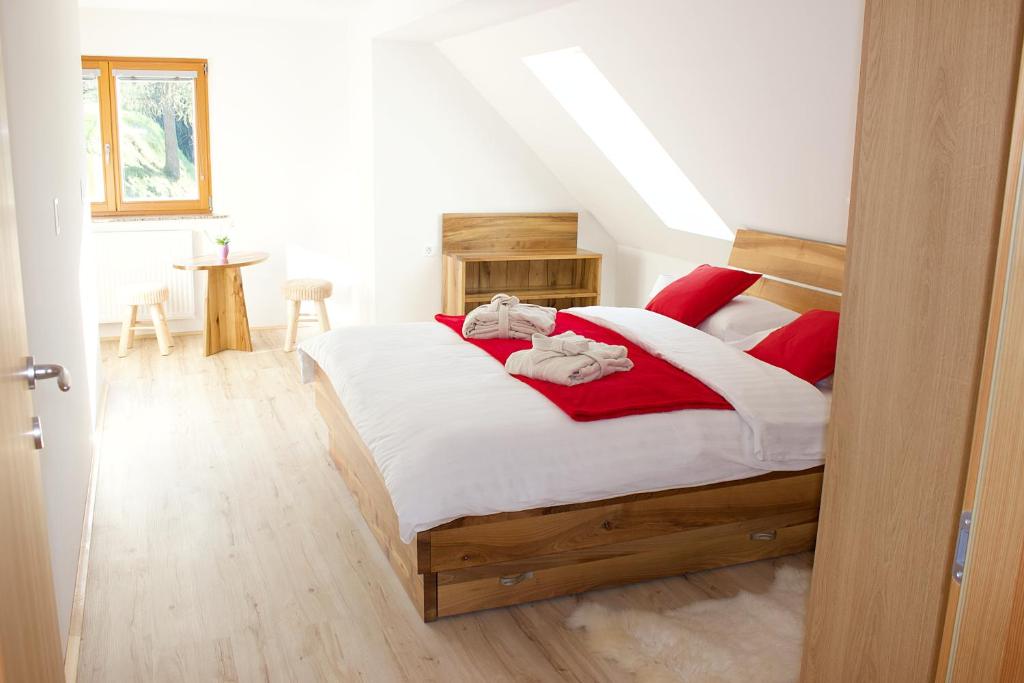1 dormitorio con 1 cama grande con almohadas rojas en Malina, en Vransko