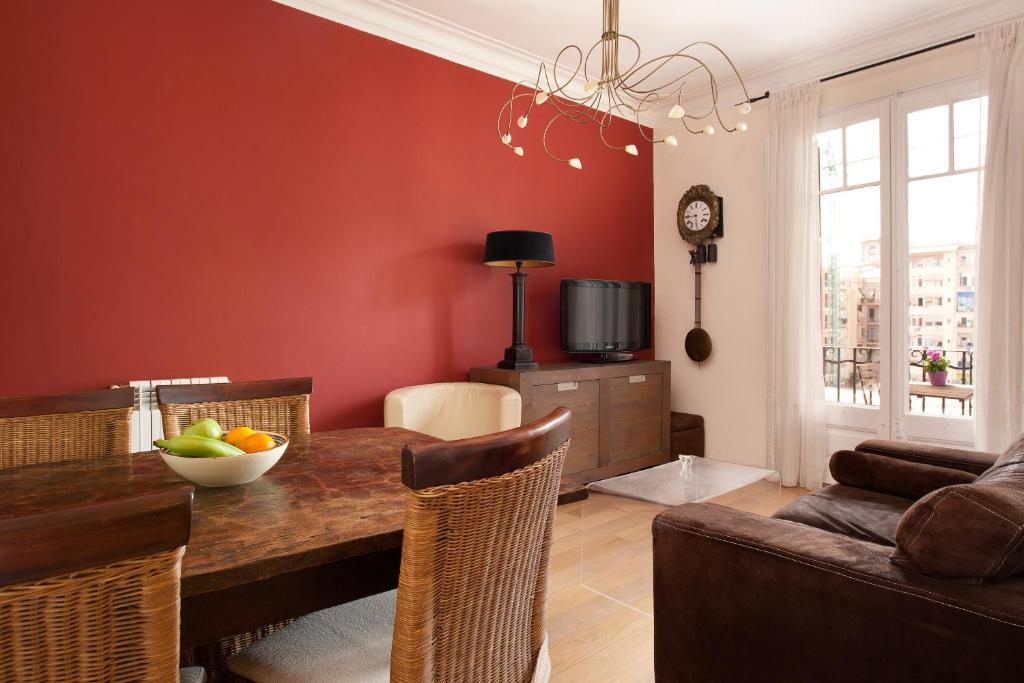 a dining room with a table with a bowl of fruit on it at Enjoy Apartments Calabria in Barcelona