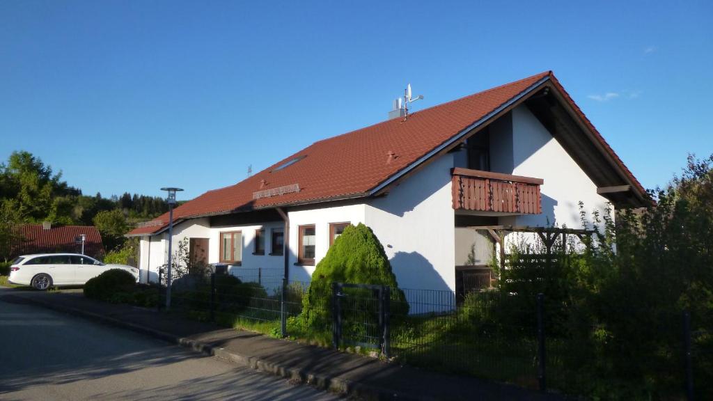 una casa bianca con tetto rosso di Ferienhaus Unteres Hart a Gomadingen