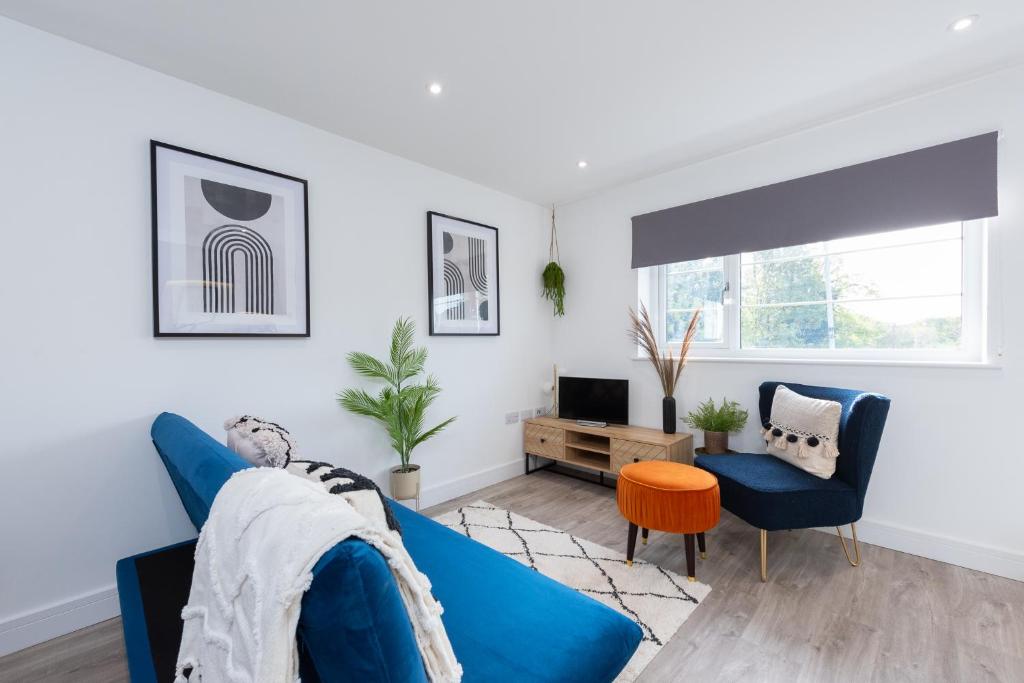 a living room with a blue couch and a tv at Stratford-Upon-Avon Luxury Snug with Free Parking in Stratford-upon-Avon