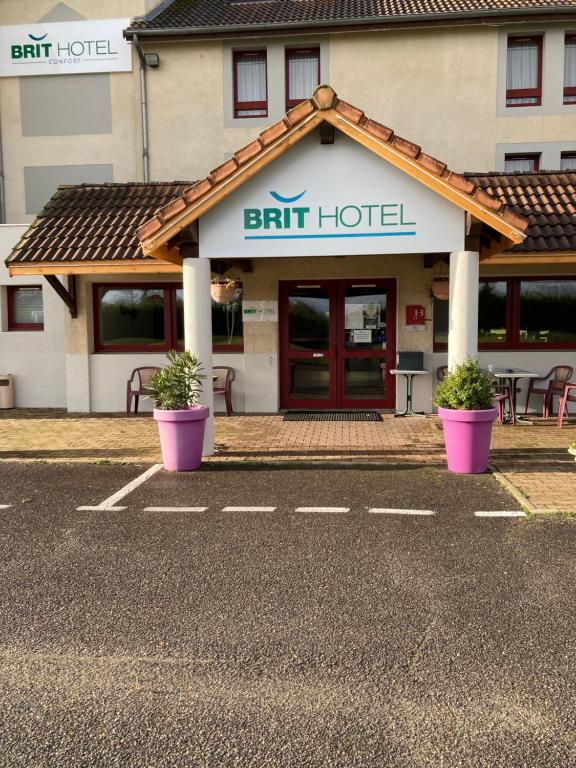 un hôtel avec deux plantes en pot devant lui dans l'établissement Brit Hotel Essentiel Moulins Avermes, à Avermes