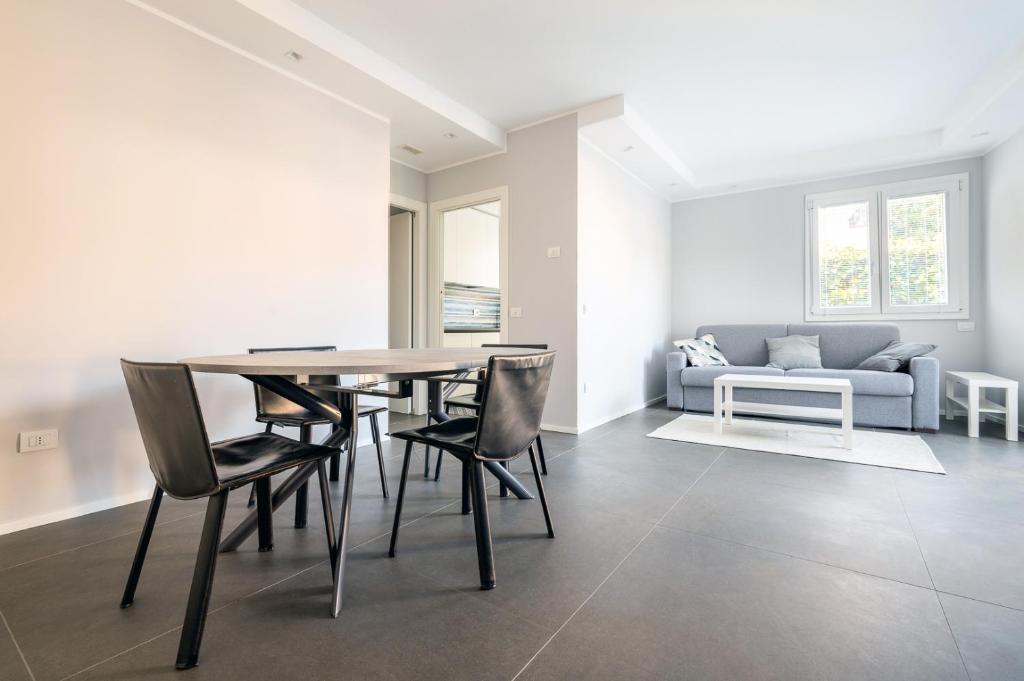 ein Esszimmer mit einem Tisch, Stühlen und einem Sofa in der Unterkunft Appartamento Maestrale in Riccione