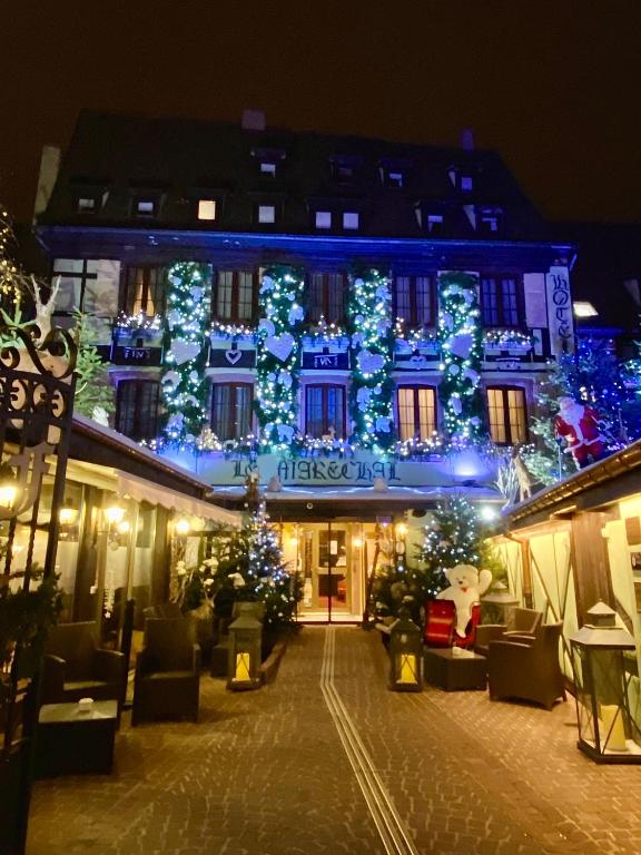 a building with christmas lights on it at night at Hotel Restaurant Le Maréchal - Teritoria in Colmar