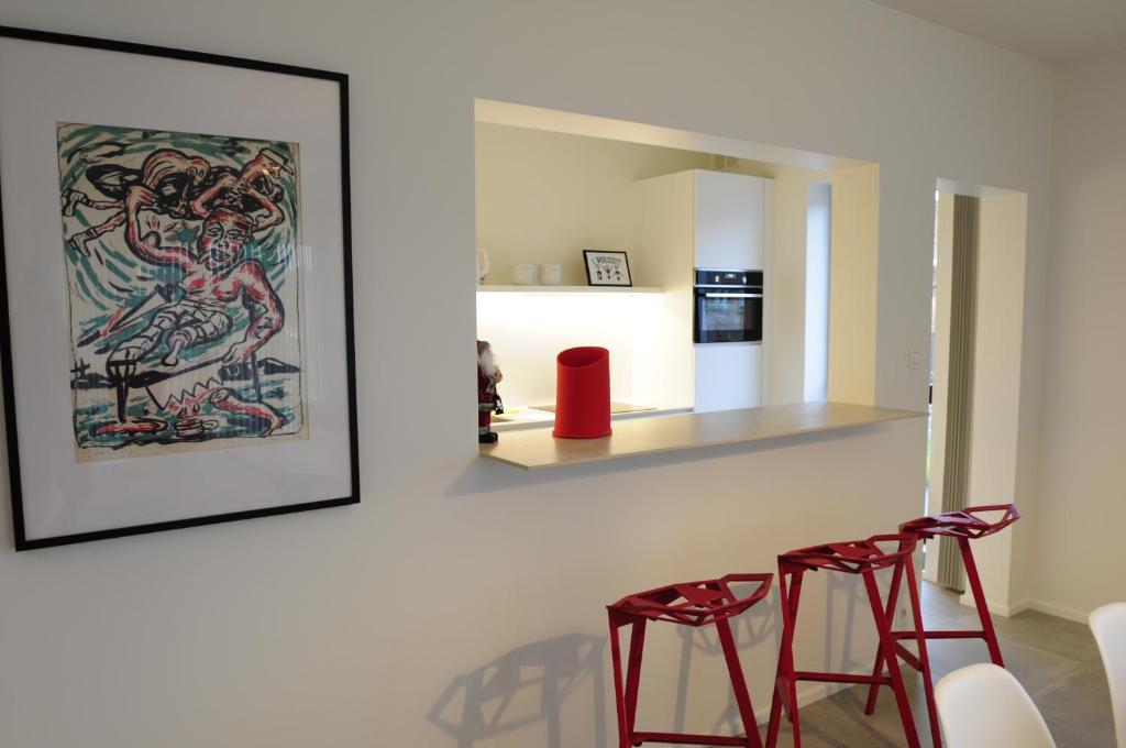a living room with two red chairs and a painting at ABC Boutique Apartments in Bruges