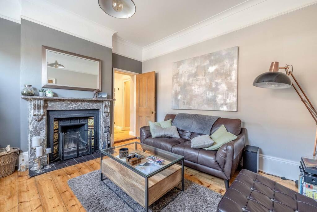 a living room with a couch and a fireplace at COUPLES RETREAT - THE LONG WALK, WINDSOR CASTLE in Windsor