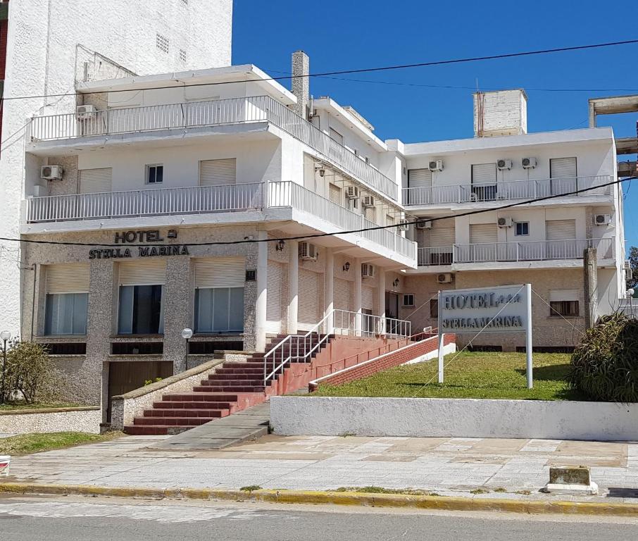 a large white building with stairs in front of it at Hotel Stella Marina in San Clemente del Tuyú