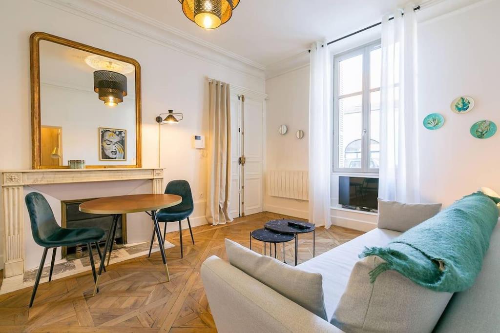 un salon avec un canapé, une table et un miroir dans l'établissement La Closerie des Cordeliers, à Dijon