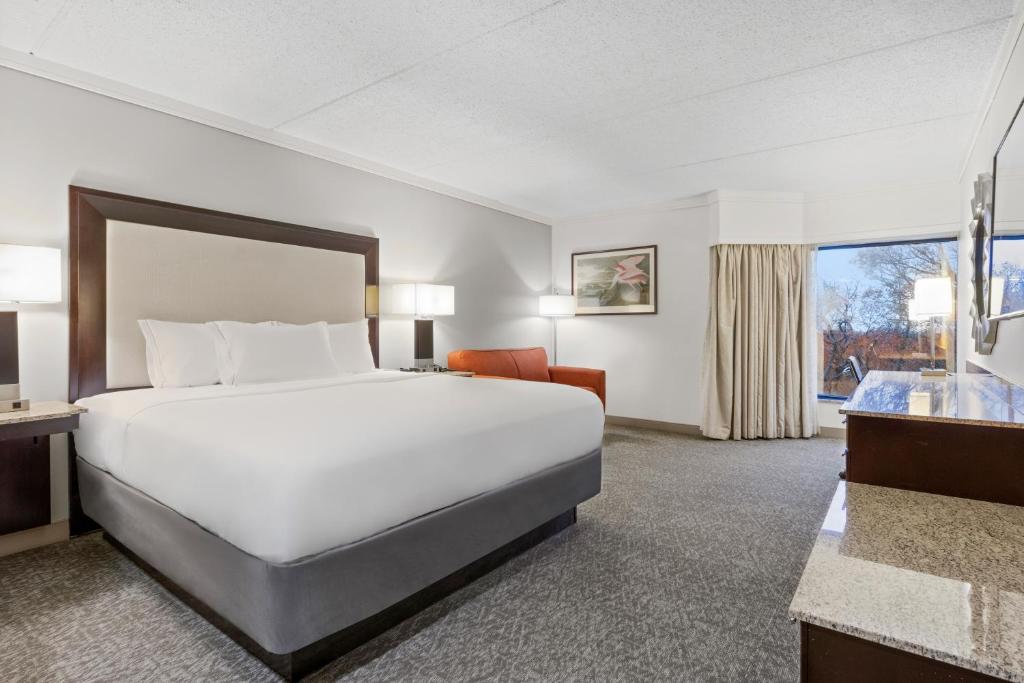 a hotel room with a large bed and a window at Woodcliff Hotel and Spa in Victor