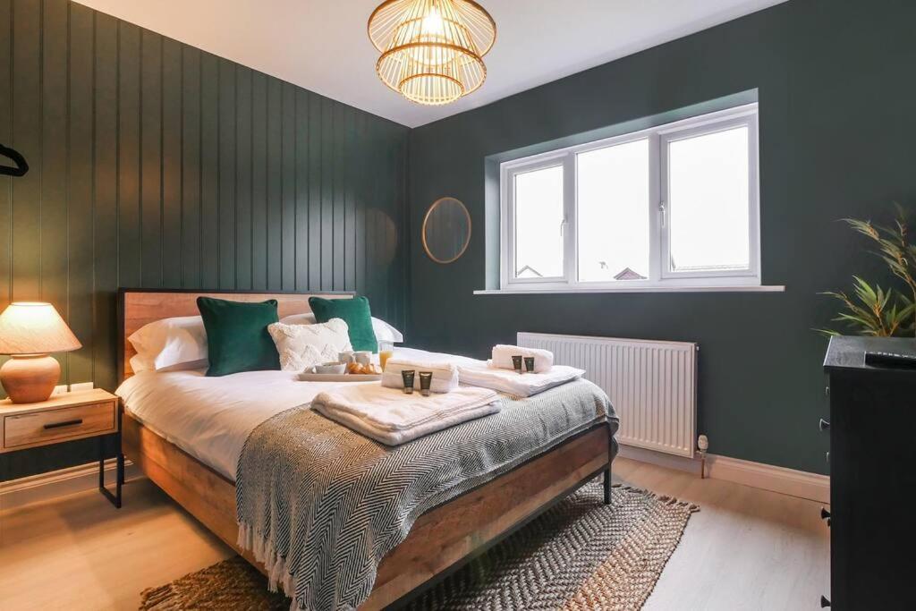 a bedroom with a large bed with green walls at Hareshaw House in Bellingham