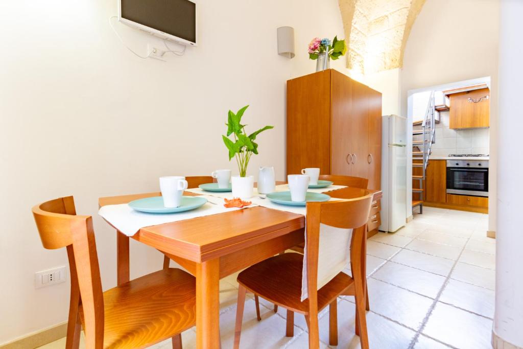 a kitchen and dining room with a wooden table and chairs at Appartamento Rosa Blu PT - MyHo Casa in Torre Canne