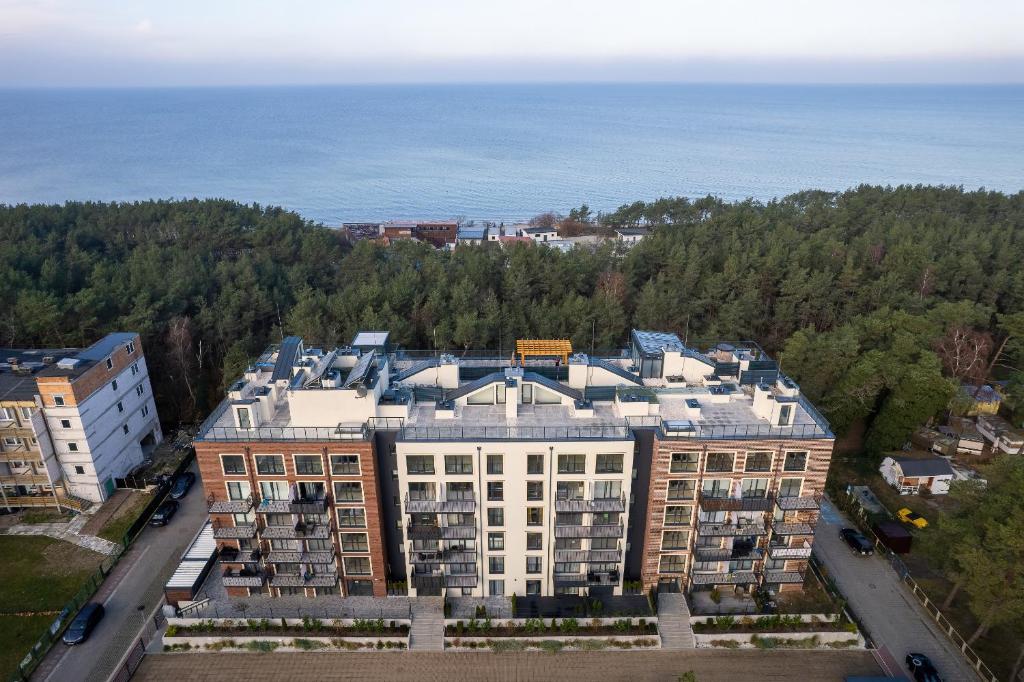 an aerial view of a building with the ocean in the background at Apartamenty Na Wydmach by Renters in Międzywodzie