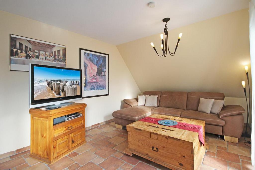 ein Wohnzimmer mit einem Sofa und einem Flachbild-TV in der Unterkunft Ostseetraum Wohnung OG in Wittenbeck