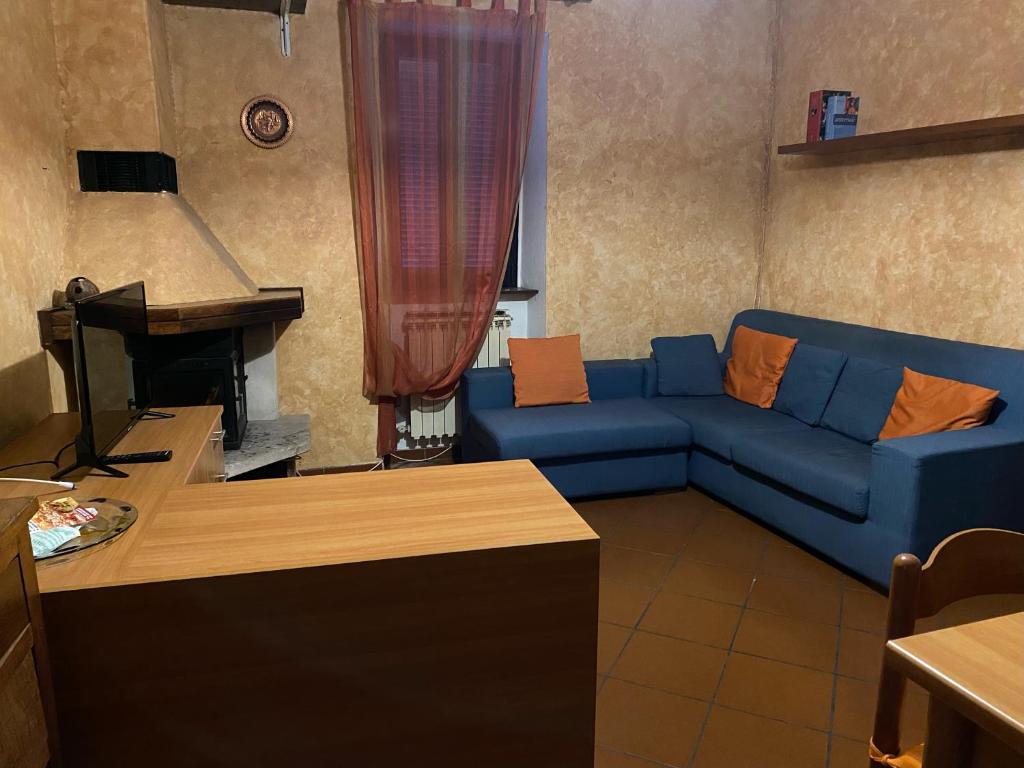 a living room with a blue couch and a piano at Lago e Monti in Colico