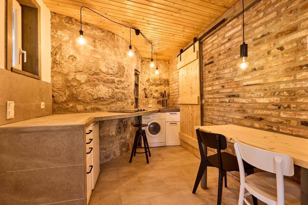 cocina con paredes de madera, mesa y sillas en Blaue Wohnung - Goldenes-Häusle, en Sulzbach an der Murr