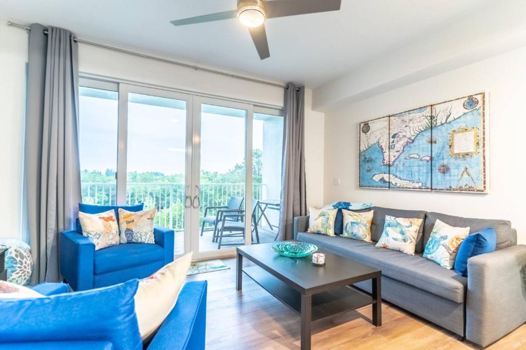 a living room with blue couches and a table at 3260 Little Harbor in Ruskin