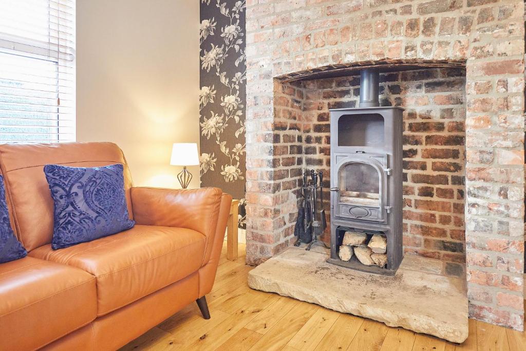 a living room with a brick fireplace with a stove at Host & Stay - Holmedene in Filey