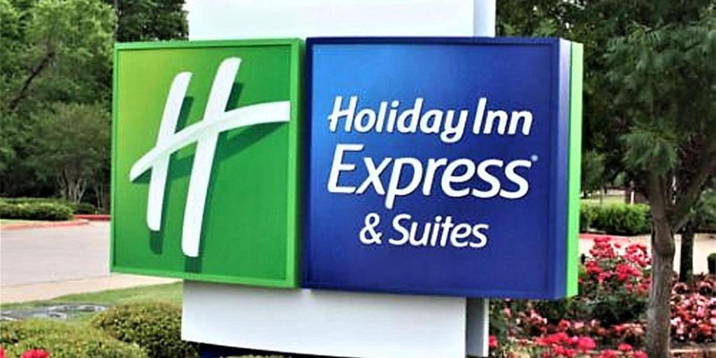 a sign for a holiday inn express and suites at Holiday Inn Express & Suites - Detroit - Dearborn, an IHG Hotel in Dearborn