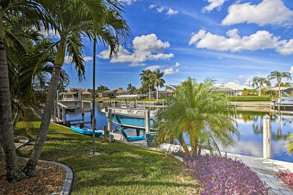 a marina with palm trees and a boat at Canal Waterfront Home with Private Pool and Dock! in Punta Gorda
