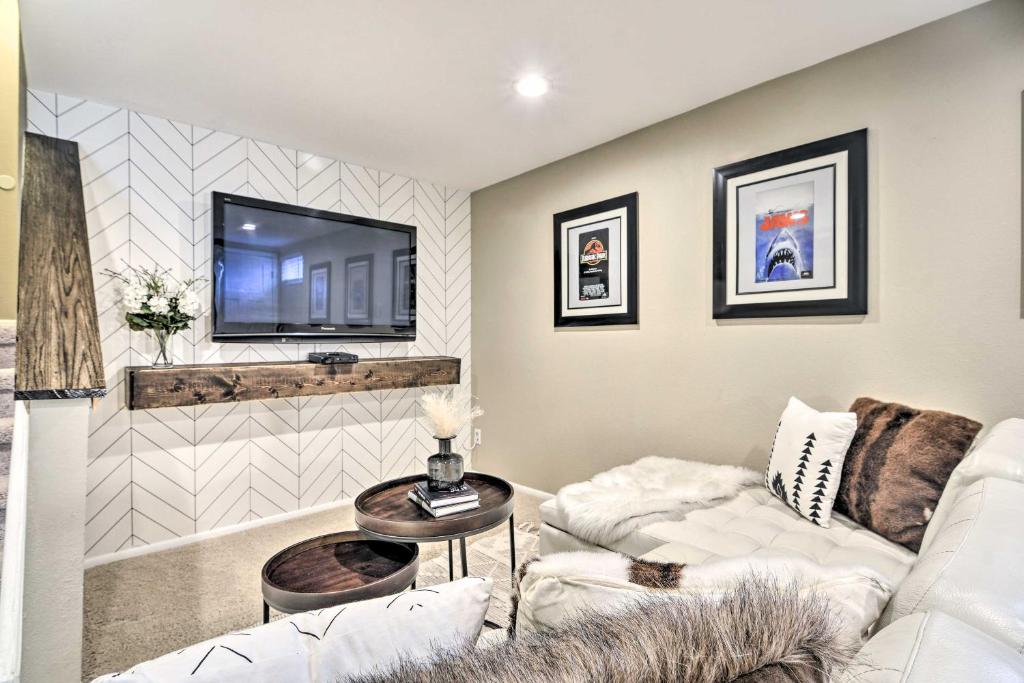 uma sala de estar com um sofá branco e uma televisão em Arvada House with Fire Pit and Outdoor Kitchen! em Arvada