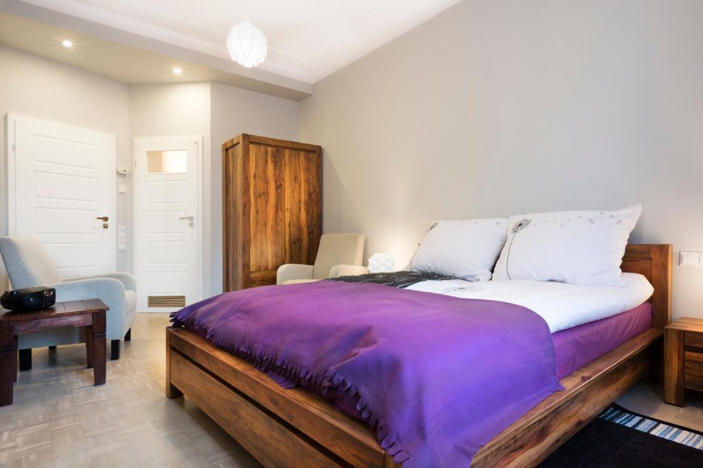 クラクフにあるMikolajska Residenceのベッドルーム(紫の毛布を使用した大型ベッド1台付)