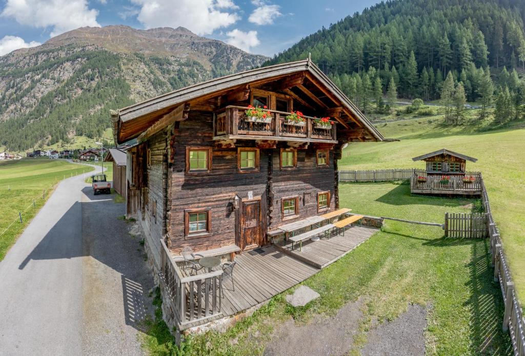 eine Aussicht auf ein Holzhaus auf einem Feld in der Unterkunft Landhaus im Grünen in Sölden