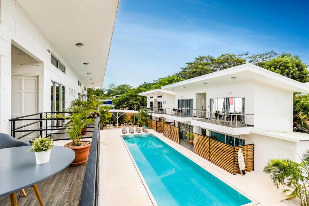 un balcón abierto con piscina y una casa en In the Shade Hotel - Coworking - 300Mbit - Adults Only en Tamarindo