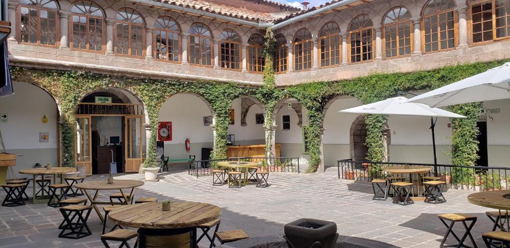 een binnenplaats met tafels en stoelen in een gebouw bij Hommam in Cuzco