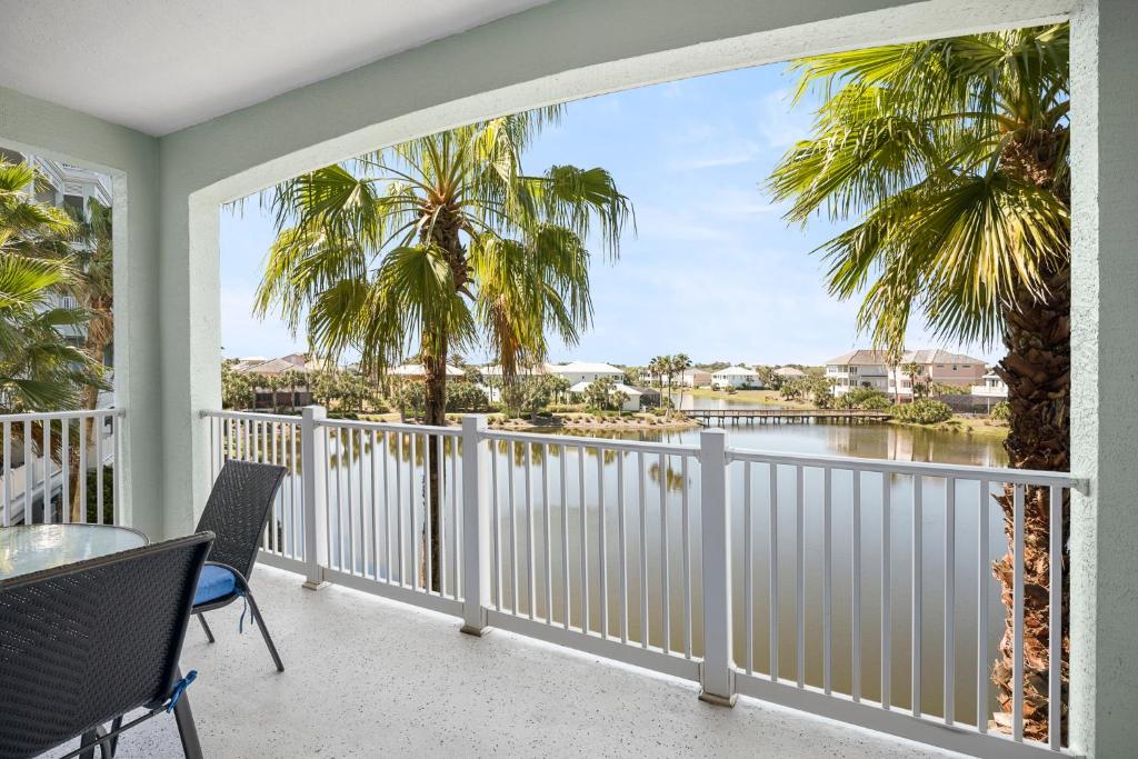 a balcony with a view of the water and palm trees at 1032 Cinnamon Beach, 3 Bedrooms, Elevator, 2 Heated Pools, Spa, Wifi, New HDTV, Sleeps 6 in Palm Coast