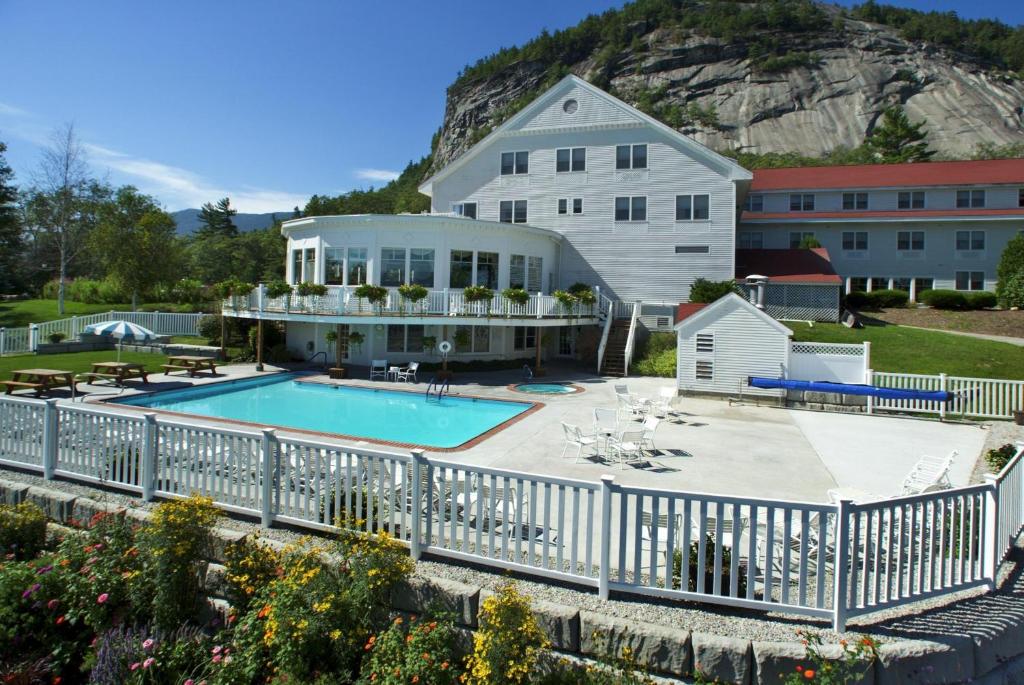 a large house with a swimming pool in front of it at White Mountain Hotel and Resort in North Conway