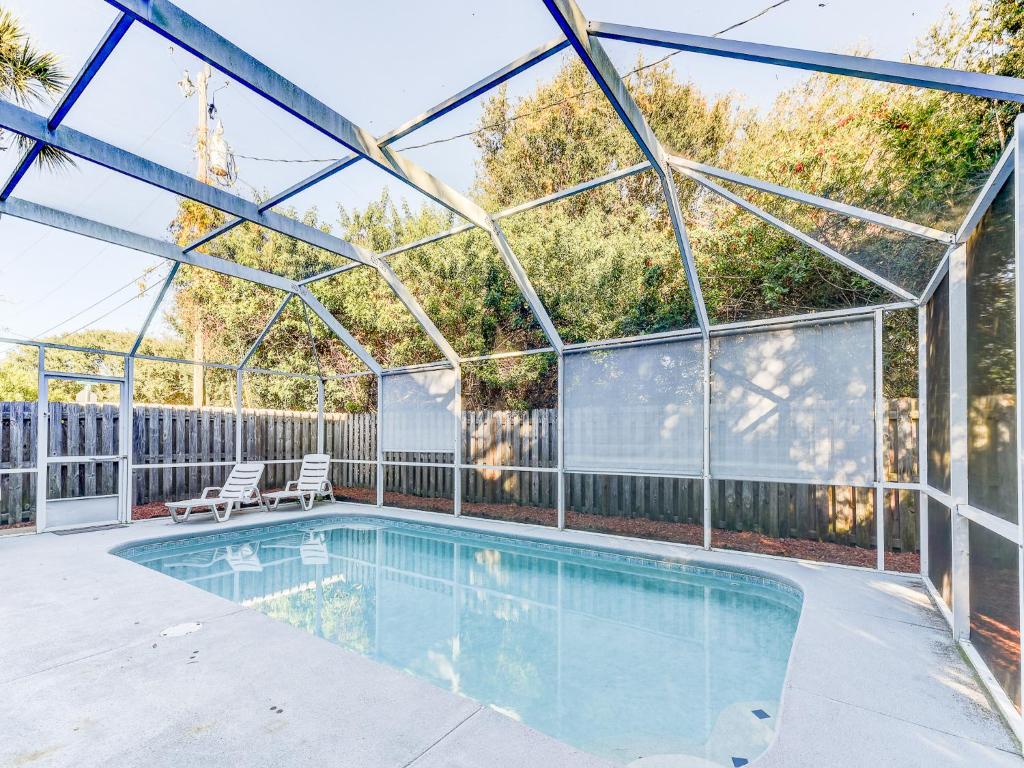 a swimming pool in a glass house with a patio at Avery's Beach Bungalow, 2 Bedrooms, Sleeps 7, Private Pool, Pet Friendly in Butler Beach
