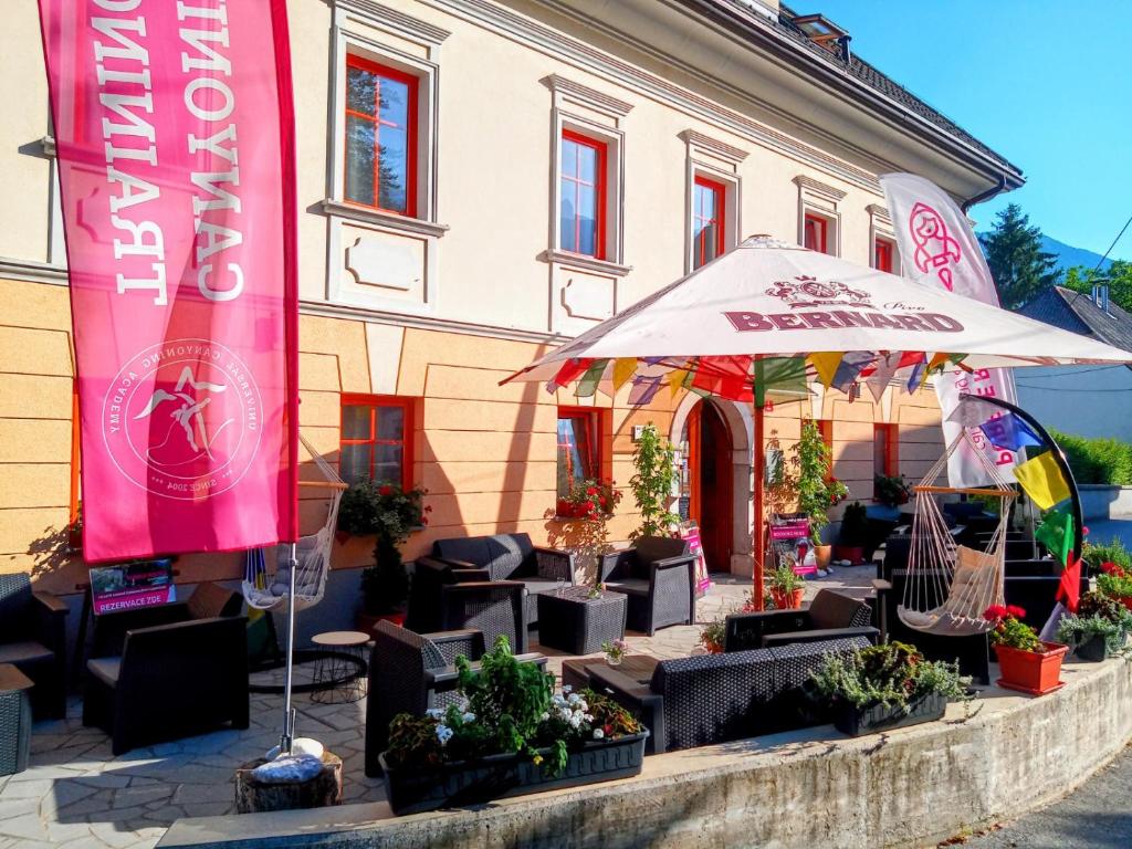 a building with a bunch of chairs and an umbrella at Garni Hotel Bovec in Bovec