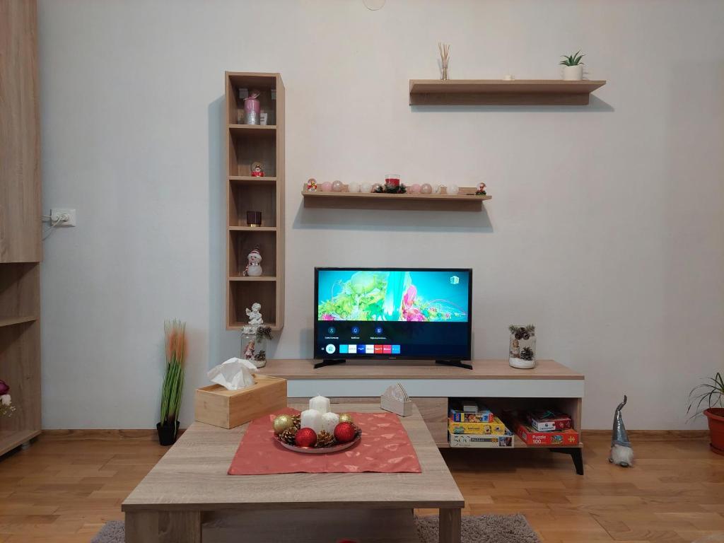 a living room with a flat screen tv and a table at Apartament Ambrus in Sighişoara
