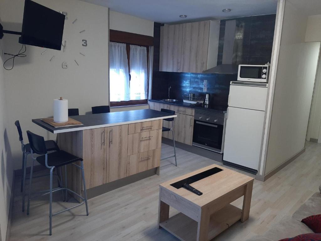 a kitchen with a white refrigerator and a table at Piso amplio y reformado para grupos in Felechosa