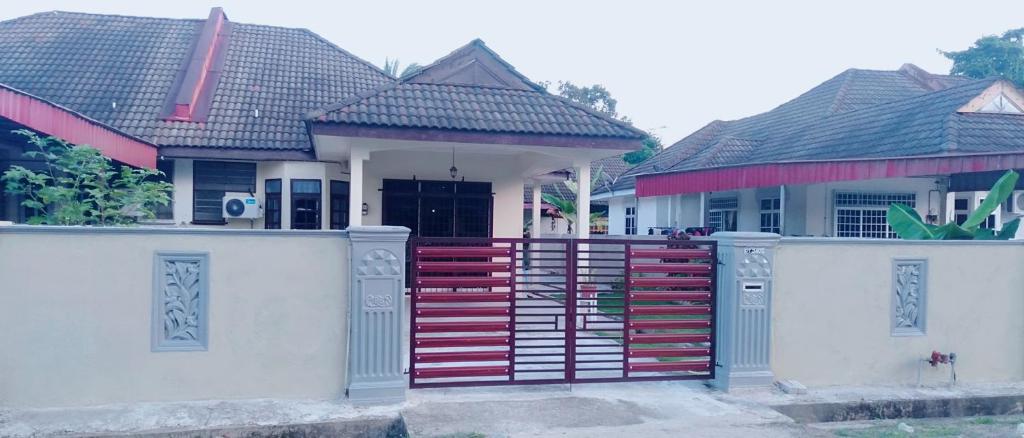 a house with a red fence in front of it at Sofea guest house kemaman in Cukai