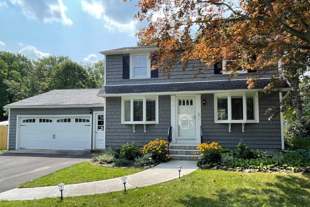 a house with a driveway and a garage at Rochester House with Fire Pit, Grill and Patio! in Rochester