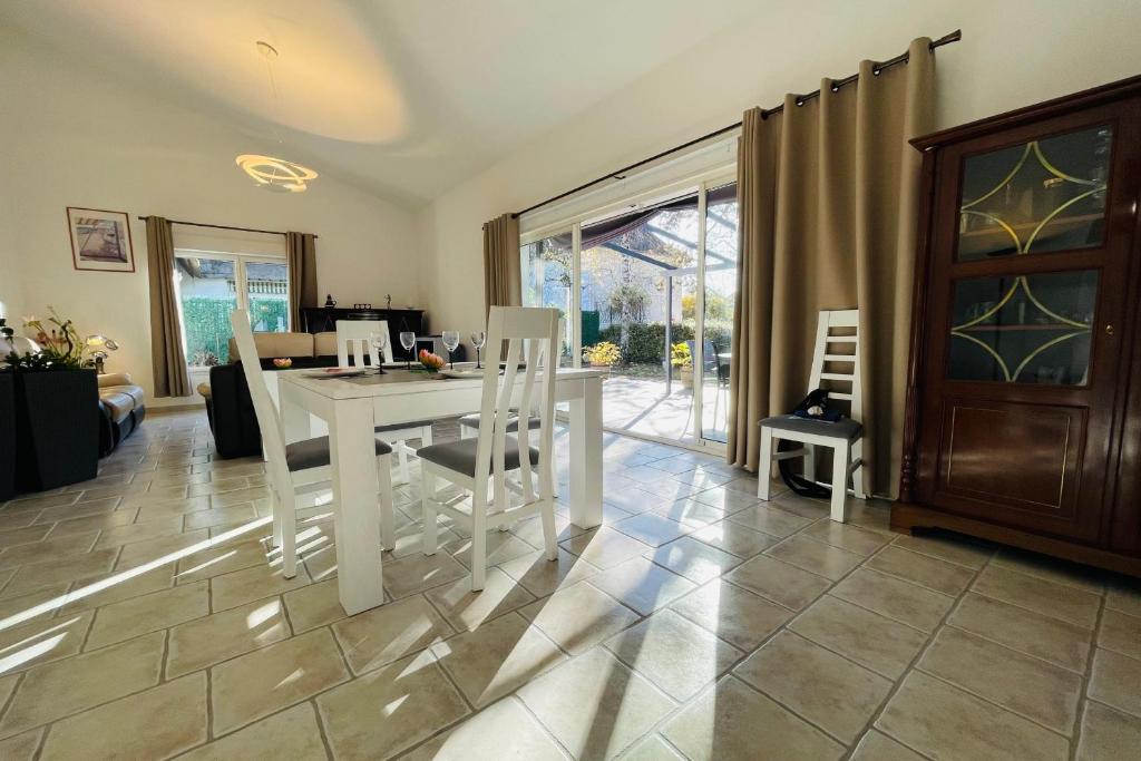 - un salon avec une table et des chaises blanches dans l'établissement Beautiful house with large terrace in the heart of Touraine, à Saint-Avertin