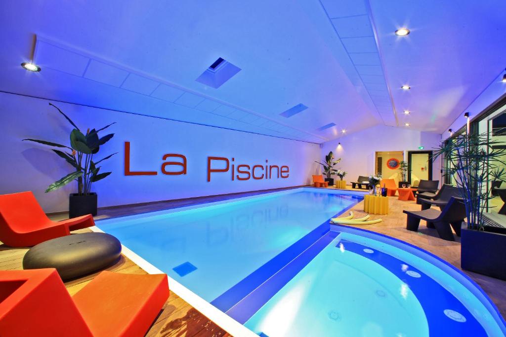 una piscina in una camera d'albergo con cartello alla piscine di Logis Hôtel La Chaize a Noirmoutier-en-l'lle