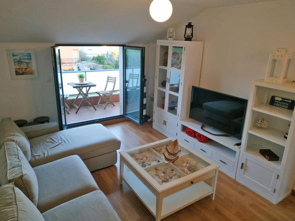 sala de estar con sofá y TV en O Faro, a 150 mtrs de playa Corna, en Palmeira