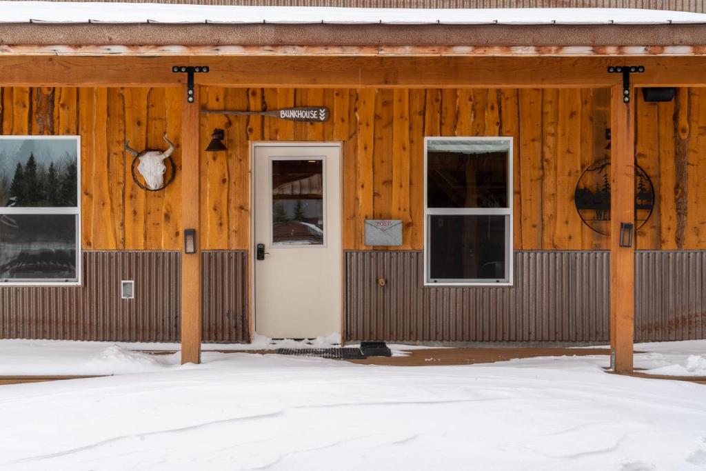 a wooden building with a white door and windows at Bunkhouse in West Yellowstone