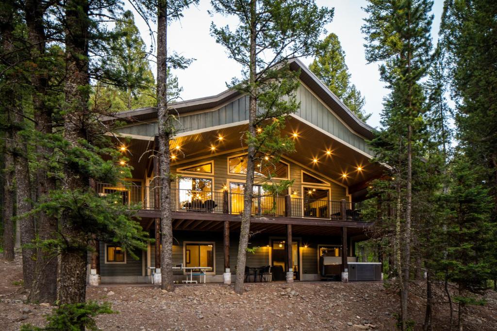 una casa en el bosque con luces en My Yellowstone Retreat, en Island Park
