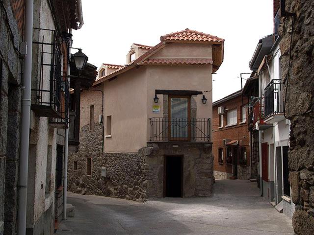 an alley with a building with a balcony at La Posada del Tiétar in Santa Maria del Tietar