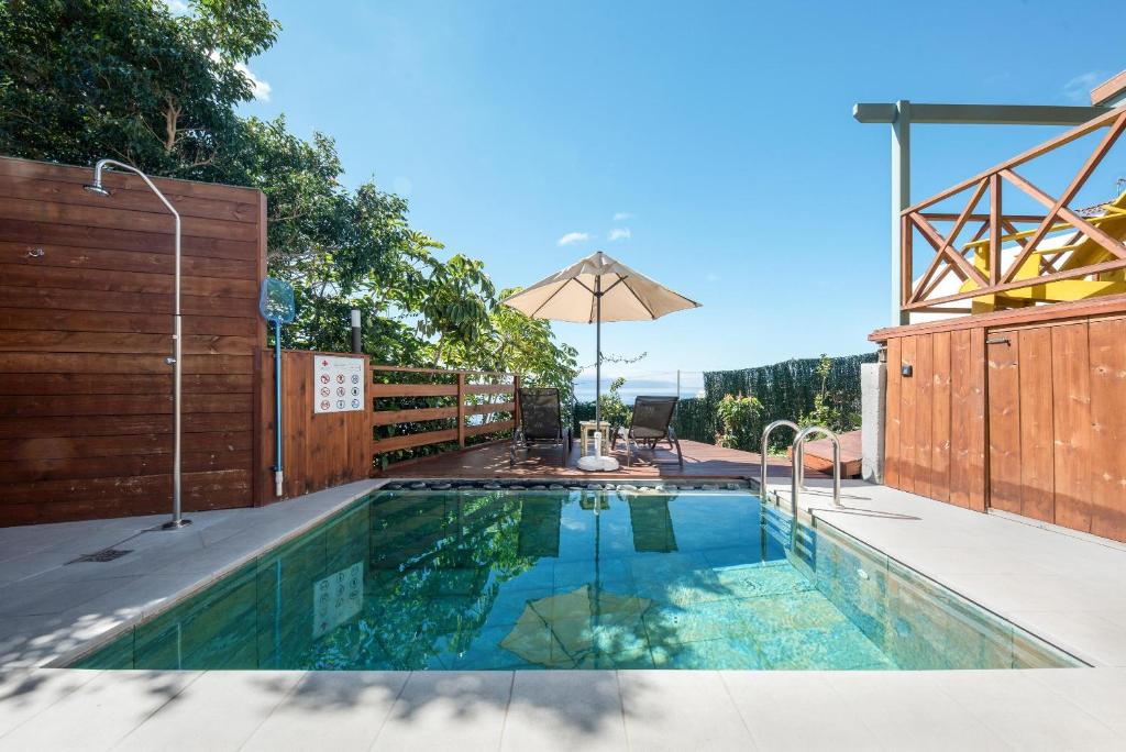 una piscina en un patio trasero con una valla de madera en Las Hermanas A en Guía de Isora
