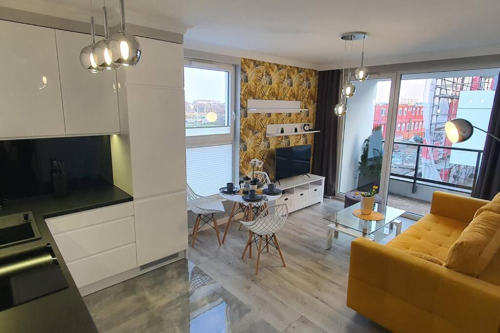kuchnia i salon z kanapą i stołem w obiekcie Apartament3City w Gdańsku