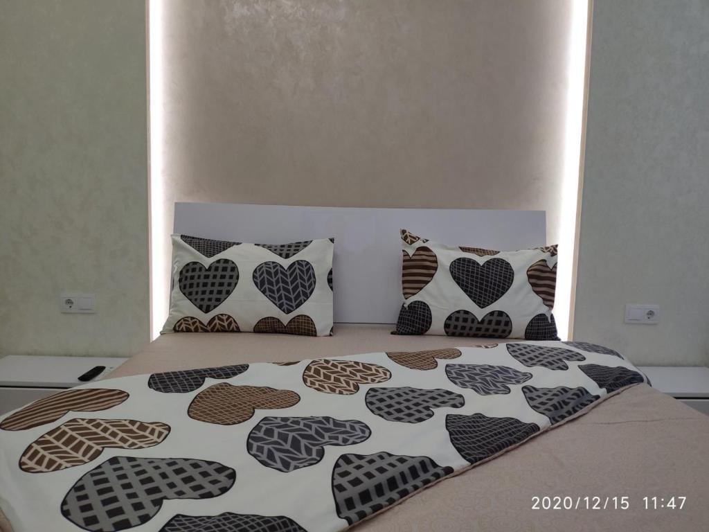 1 cama con edredón y almohadas en blanco y negro en Люкс апартаменти в ЖК Театральному.Центр міста, en Rivne
