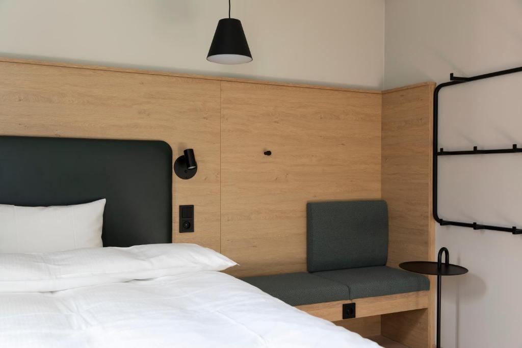 a bedroom with a bed and a chair at Comfort Hotel Xpress Youngstorget in Oslo